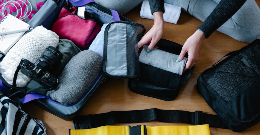 A woman arranging clothes and accessories into a suitcase, preparing for travel.